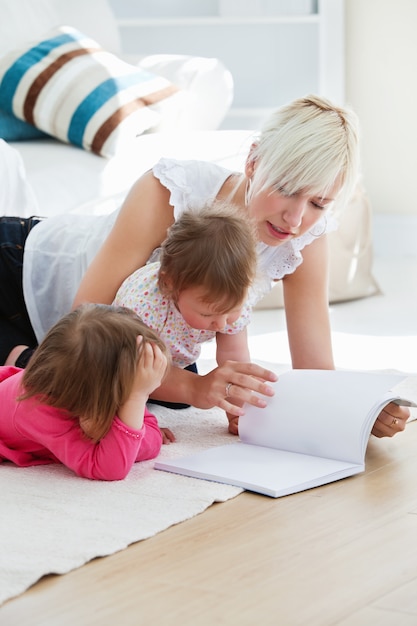 Happy family reading a book on the floor 