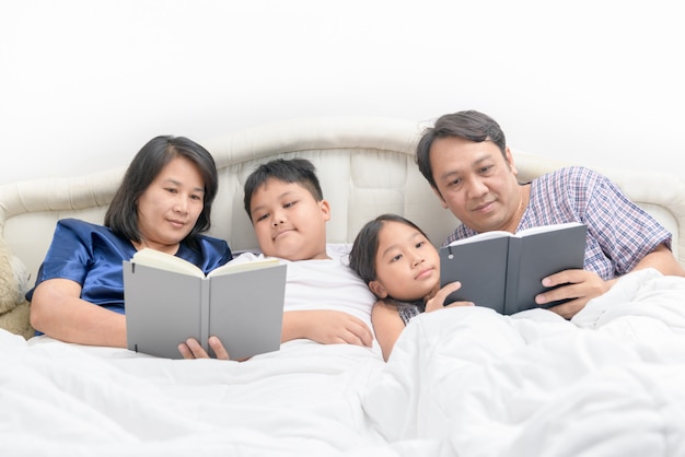 Happy Family reading a story on bed 