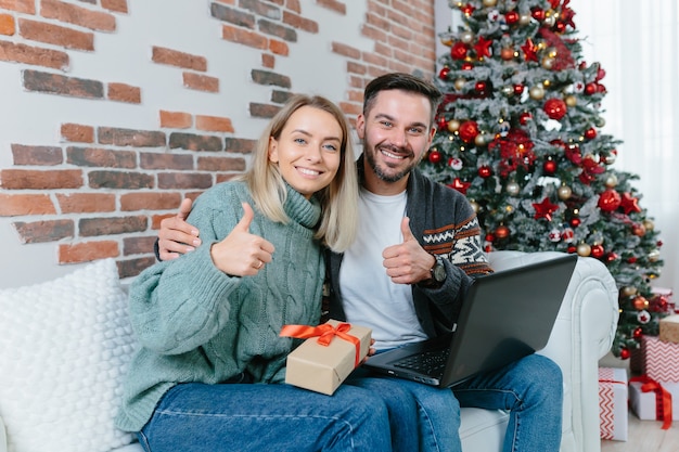 Happy family received confirmation of credit and money on bank account, on credit card, rejoice at home sitting on sofa during New Year and Christmas holidays