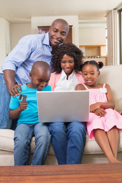 Happy family relaxing on the couch shopping online