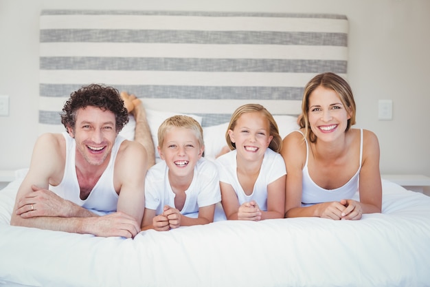 Happy family resting on bed