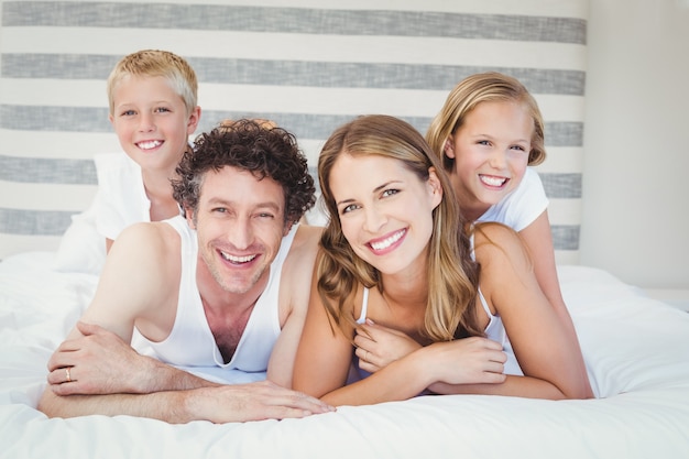 Happy family resting on bed