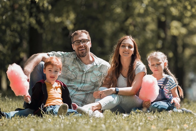 Happy family resting on the lawn in the city Parkthe concept of family entertainment