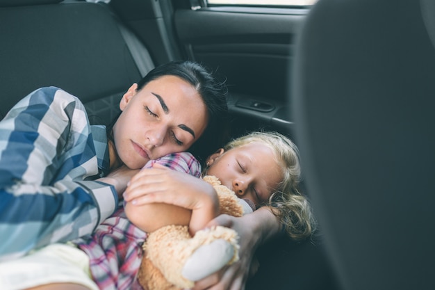 Happy family on a road trip in their car. Dad, mom and daughter are traveling by the sea or the ocean or the river. Summer ride by automobile