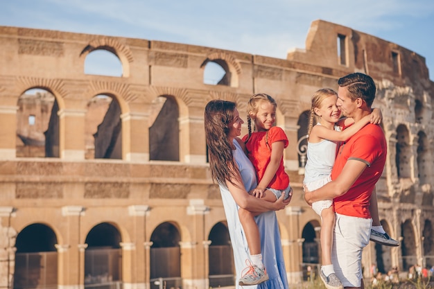 Famiglia felice a roma su sfondo colosseo.