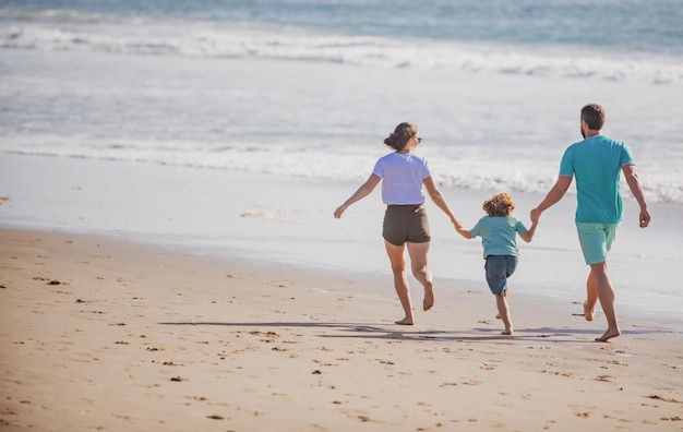 Счастливая семья, бегущая по пляжу на закате, семейное путешествие, концепция здоровых людей