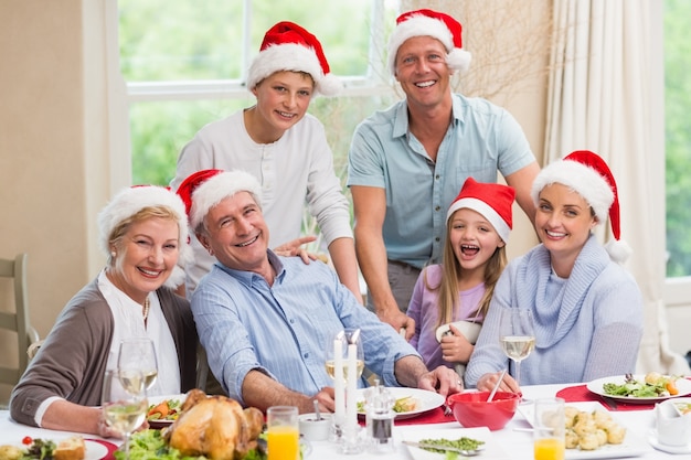 Famiglia felice in cappello della santa che guarda l'obbiettivo