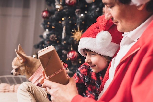 Happy family and in Santa hat with Christmas gift