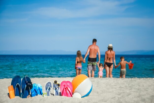 Happy family on the sea with slippers on nature background