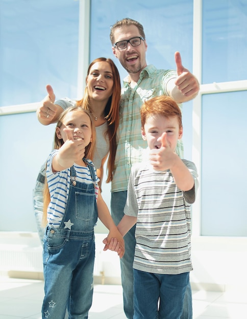 Foto famiglia felice che mostra i pollici in su foto con lo spazio della copia