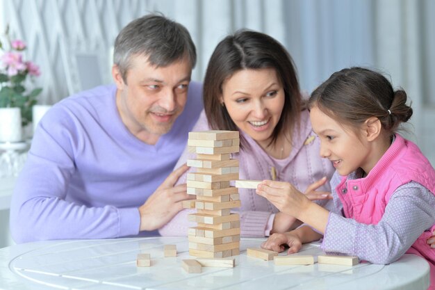 写真 テーブルに座って、木製のブロックで遊んで幸せな家族