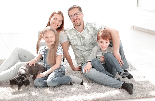 Happy family sitting on the carpet in a new apartment