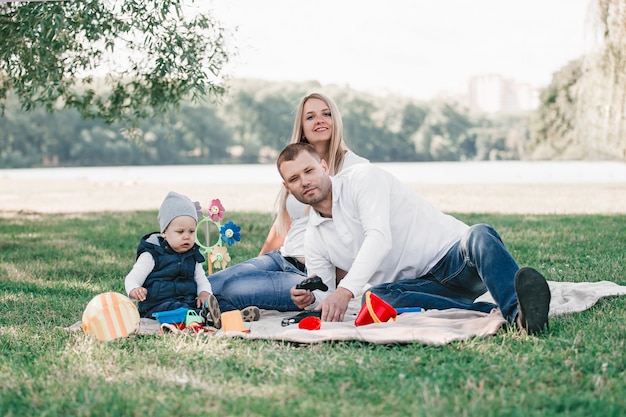 Happy family sitting on the grass in the park