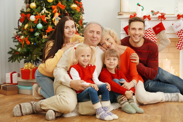 Happy family sitting in living room decorated for Christmas