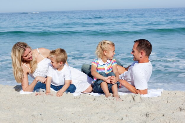 Счастливая семья, сидя на песке