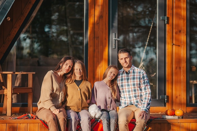 Happy family sitting on the terrace of their house in autumn