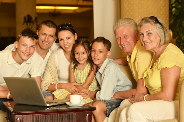 Photo happy family sitting with laptop on table