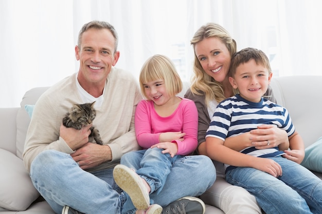 Happy family sitting with pet kitten together