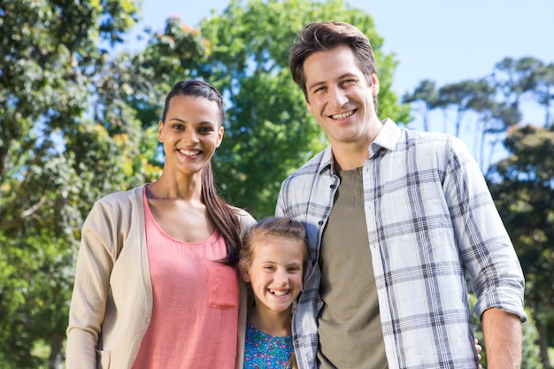 Happy family smiling at camera in the park