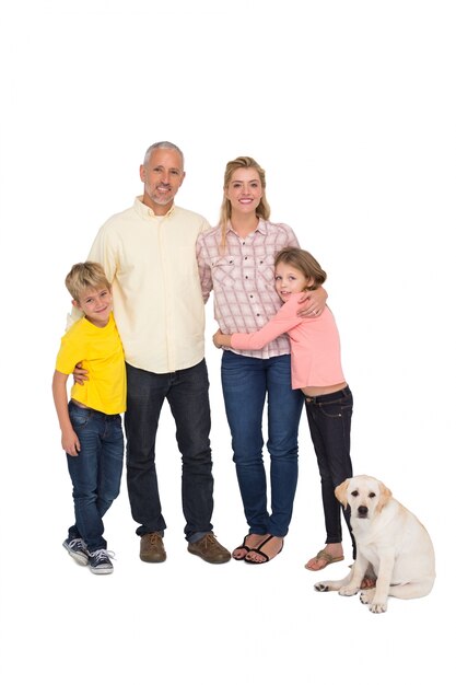 Foto famiglia felice che sorride alla macchina fotografica con il cane