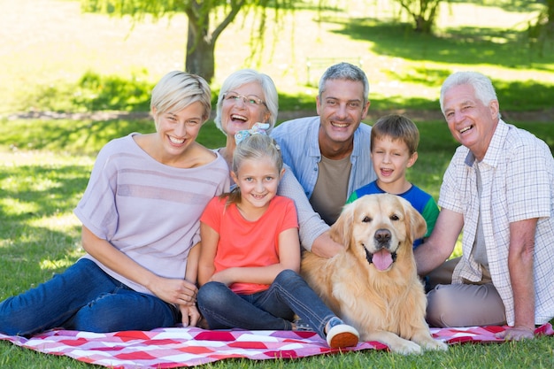 Happy family smiling at the camera with their dog