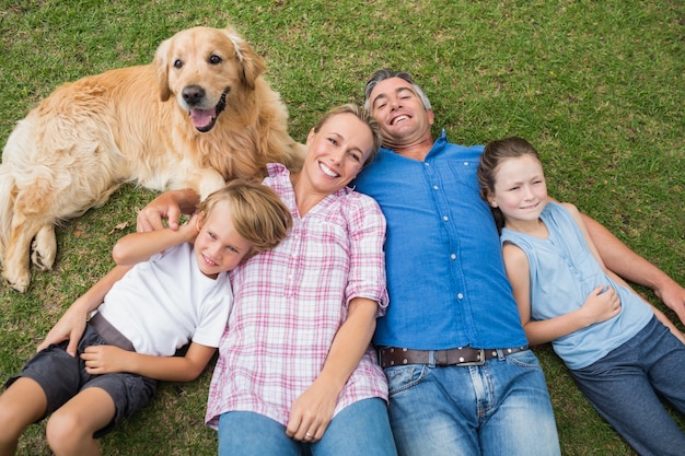 犬と一緒にカメラで笑っている幸せな家族