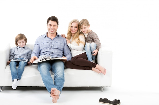 Happy family on sofa isolated on white