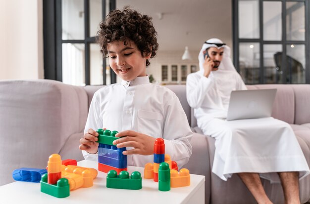 Happy family spending time together. Arabian father and his son making different activities at home