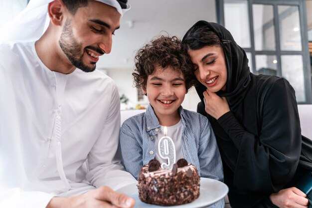 Famiglia felice che trascorre del tempo insieme. genitori arabi e bambino festeggiano insieme il suo compleanno