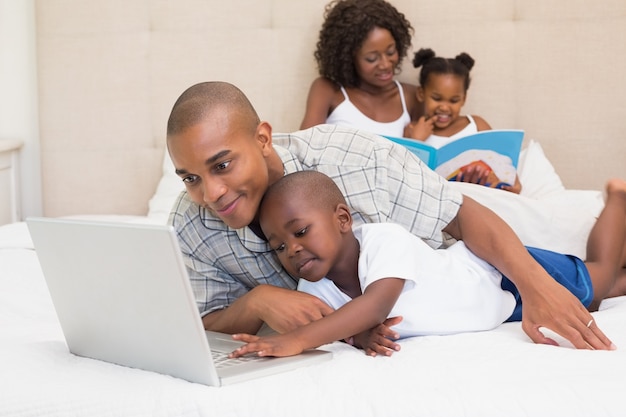 Happy family spending time together on bed