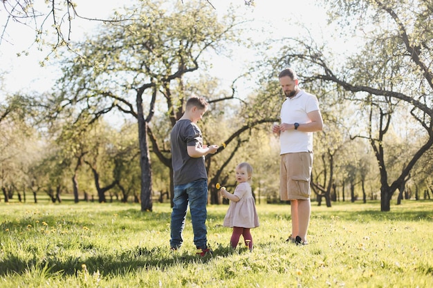 Happy family spending time together outside in nature Father and children playing in the garden