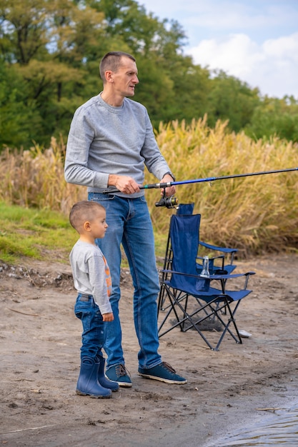 幸せな家族は湖で釣りを一緒に過ごす