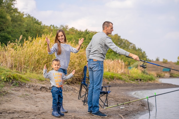 A happy family spends time together; they teach their son to fish.