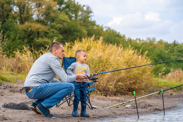 Photo a happy family spends time together; they teach their son to fish.