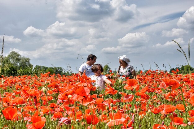 Happy family standing amidst flowers on field