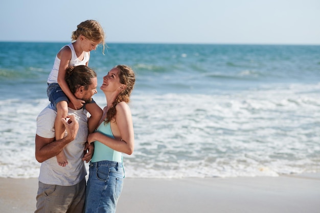 Famiglia felice in piedi sulla spiaggia