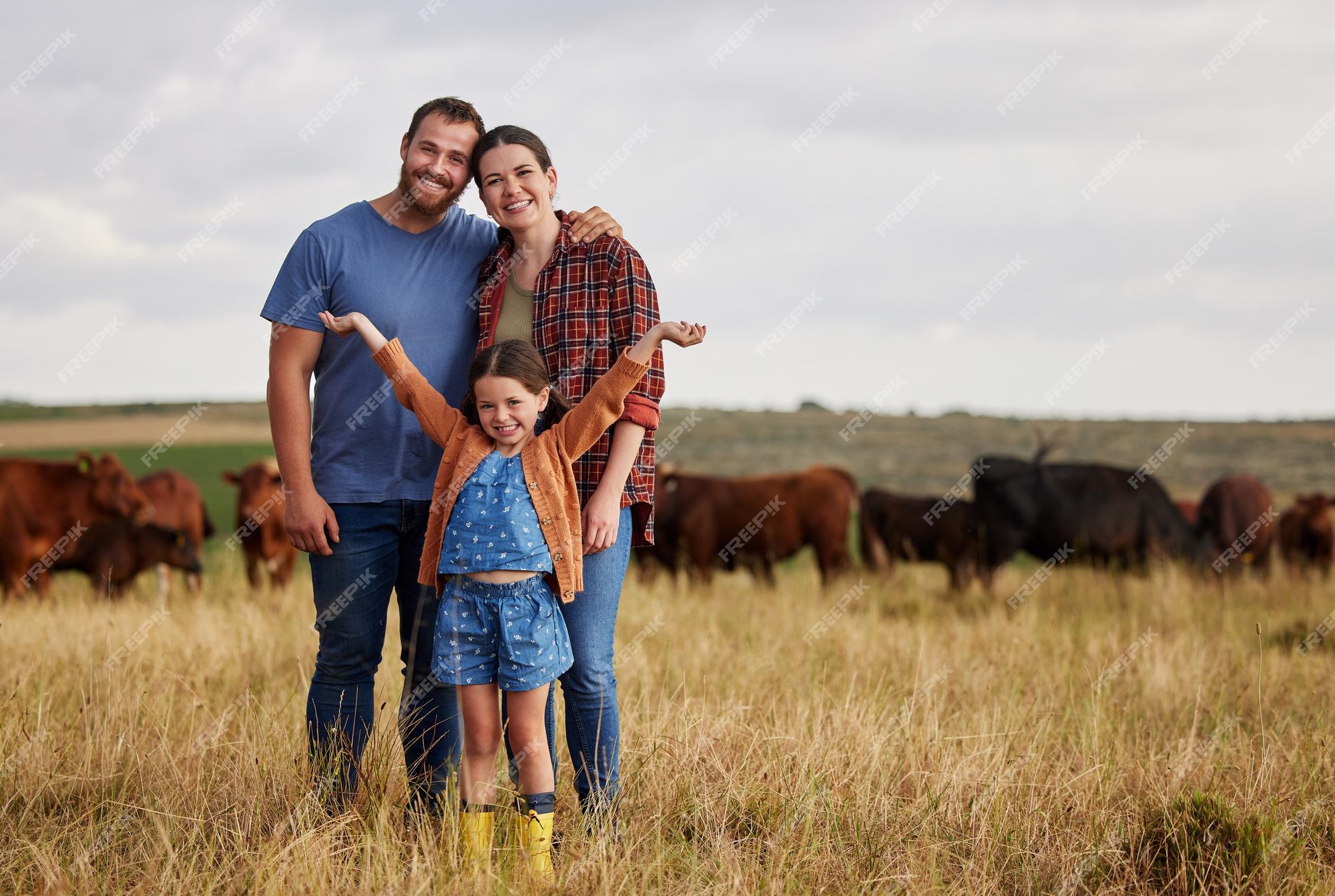 Premium Photo | Happy family standing on a farm cow in background and with a vision for growth in industry portrait countryside couple people or farmer in a field of grass cattle Premium Photo | Happy family standing on a farm cow in background and with a vision for growth in industry portrait countryside couple people or farmer in a field of grass cattle