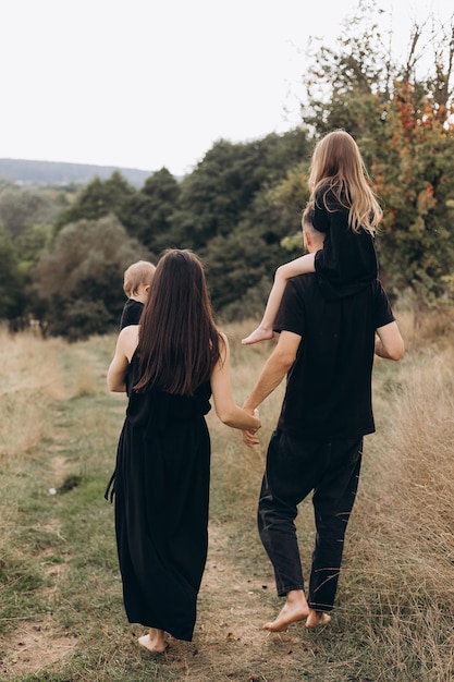 Happy family on sumer walk Mother Father and daughters walking in the Park and enjoying