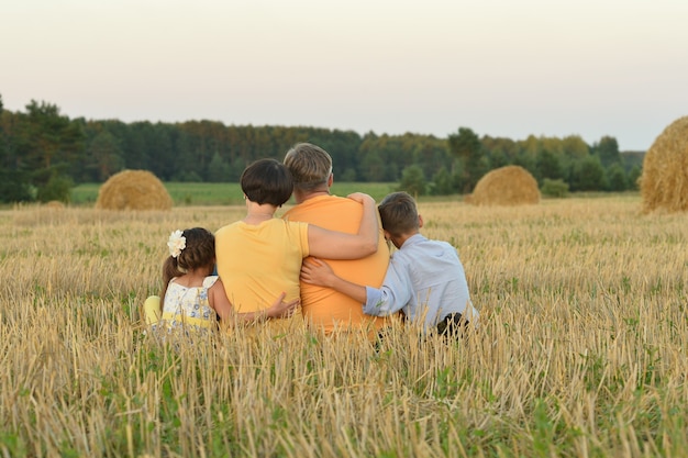 Photo happy family at summer  field back view