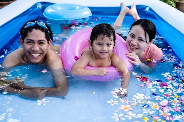 夏の時間にプールで泳いで幸せな家族。