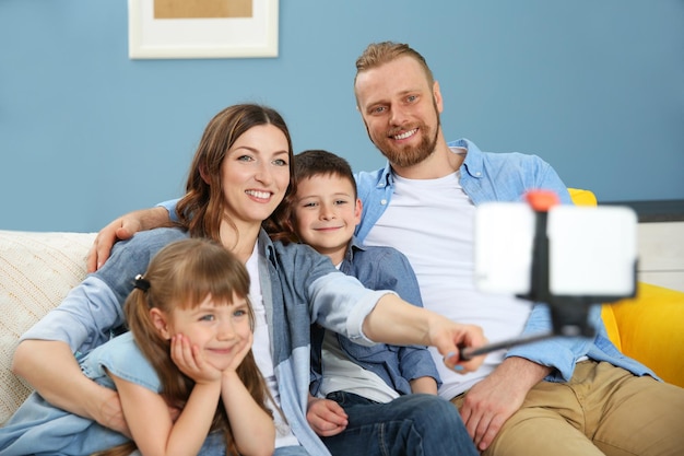 Happy family taking selfie on blue wall background