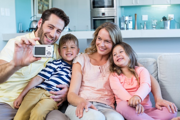 Happy family taking selfie on couch