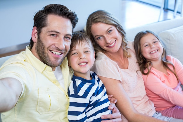 Happy family taking selfie on couch