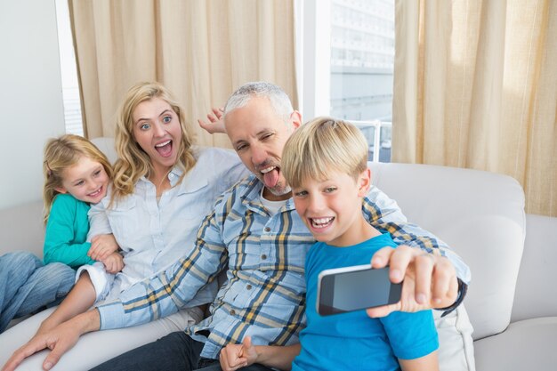 Happy family taking a selfie on couch