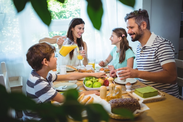 Happy family talking to each other while having breakfast together