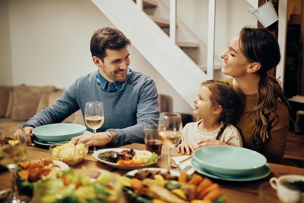 Happy family talking while eating lunch at dining table