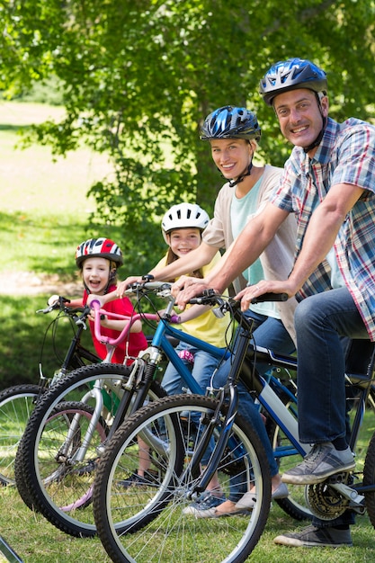 Foto famiglia felice sulla loro bici al parco