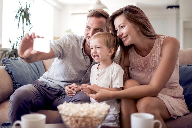 Photo happy family on their sofa at home take selfie