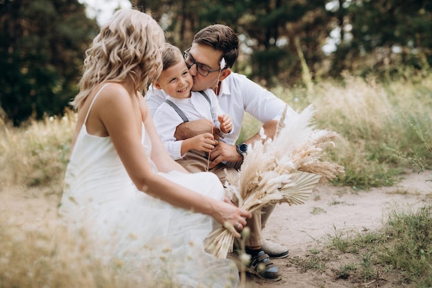 Famiglia felice tre papà mamma e figlio in una passeggiata