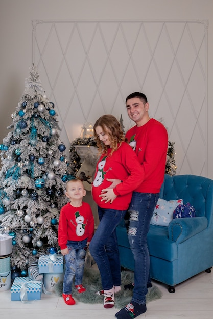 Happy family of three young mother expecting a new baby father and their little son